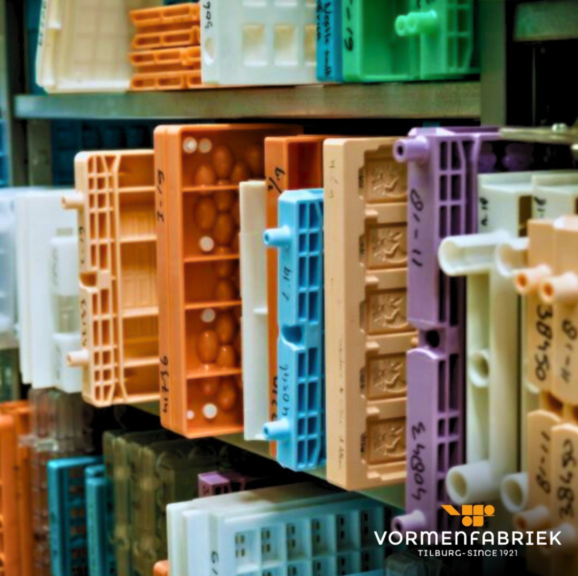 Polycarbonate moulds of various different colours and sizes with rounded construction stored in warehouse racking 